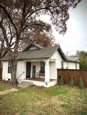 A single-story house with a front porch, a welcome sign, and a mailbox. - LadyFace Cottage: close to Magnolia & Baylor! (Waco)