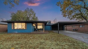 A single-story house with a blue exterior, a covered porch, and a garage.