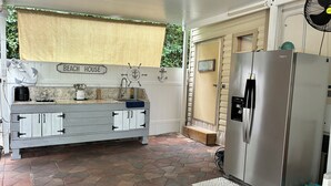 A kitchen with a granite countertop, a stainless steel refrigerator, and a tiled floor. - Cozy 1-bedroom mobile home with AC, WiFi in enchanting Key Largo (Key Largo)