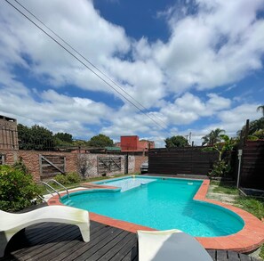 Guests can enjoy a refreshing swim in the pool surrounded by a wooden deck.