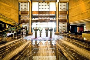 A spacious lobby with a polished marble floor, a central atrium, and a staircase on the left. - Longdu Jingyi International Resort Hotel （Ethnic Culture Park Branch） (Kaili)