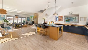 A spacious living area with a kitchen island, dining area, and seating.