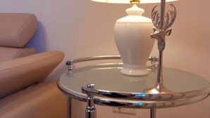 Een ronde glazen tafel met een witte lamp en een kaars.