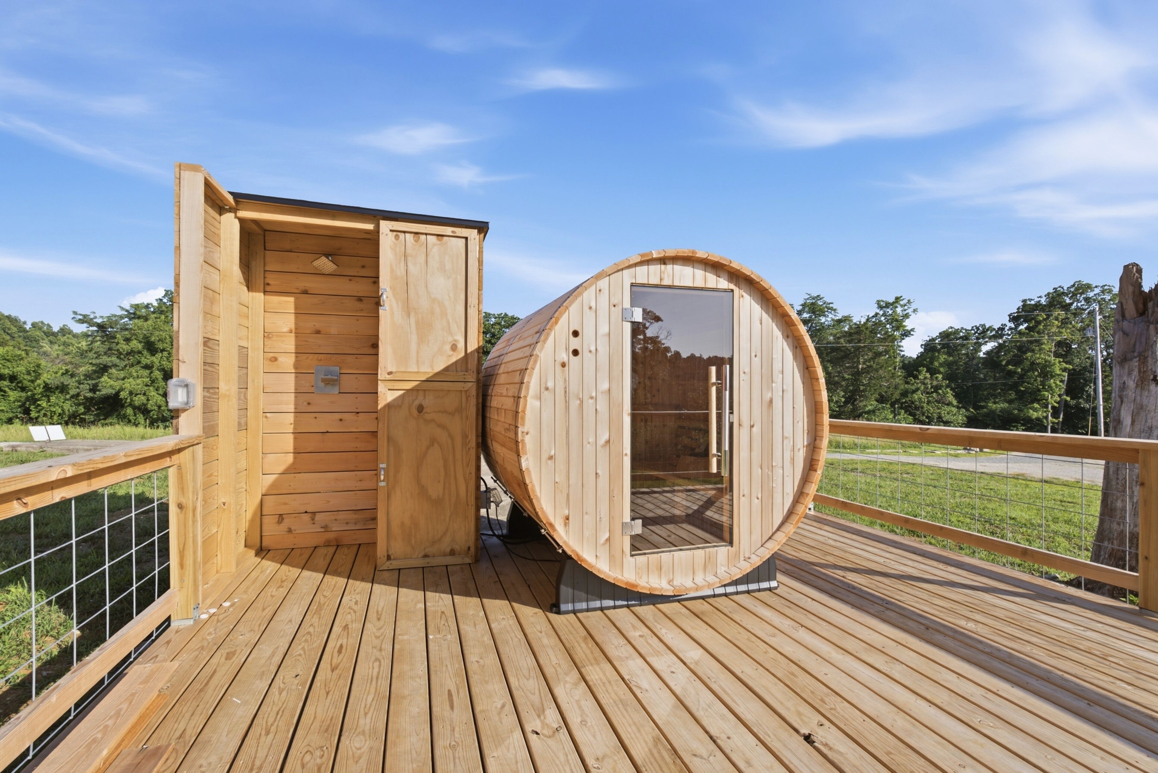 Un sauna avec une structure extérieure en bois, une porte et une fenêtre, installé sur une terrasse en bois.