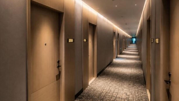 A long, narrow hotel corridor with doors on both sides, carpeted floor, and overhead lighting. - Beijing Baishang Hotel (Beijing)