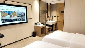 A hotel room with a large flat-screen TV, a wooden vanity with a mirror, a sink, and a bed. - Beijing Baishang Hotel (Beijing)