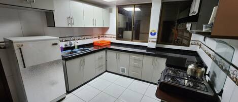 Frigorífico, utensilios de cocina y mesa de comedor