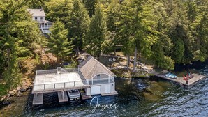 A lakeside cabin with a dock, surrounded by dense forest.