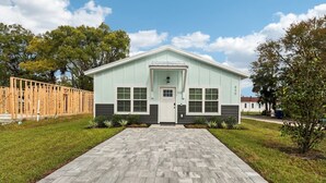 A two-story building with a light green exterior, a front entrance, and a paved driveway.