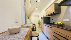 Une cuisine moderne avec des meubles en bois, un plan de travail noir et un panier de fruits.