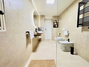Bathroom with walk in shower with a heated towel rack