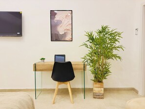 A modern workspace with a desk, chair, and a large potted plant. - Nova Plebiscito 2, Suite in Naples center (Napoli)