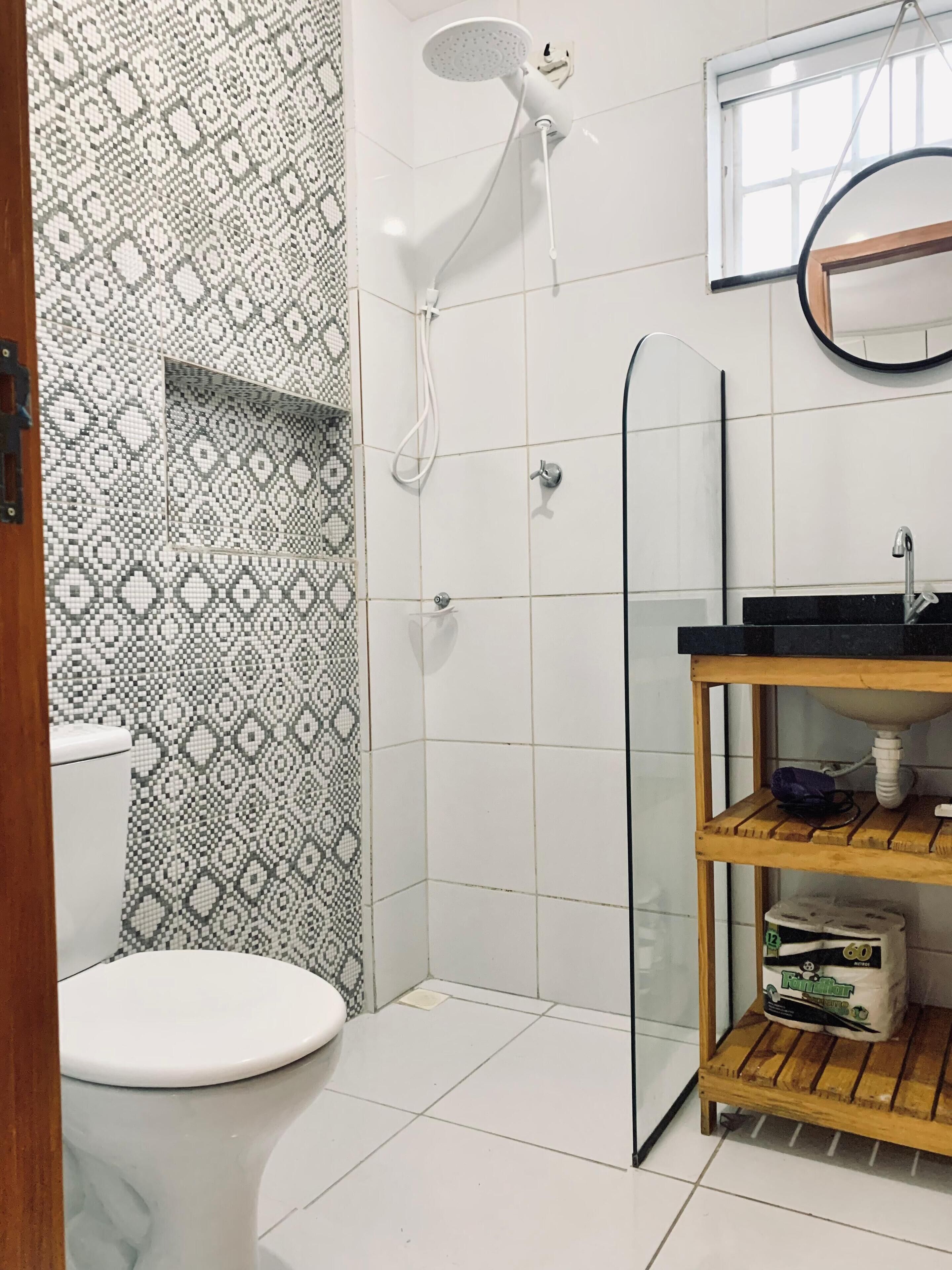 Chuveiro, secador de cabelo, toalhas de banho, papel higiênico