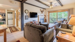 Una sala de estar acogedora con chimenea, televisor y comedor.