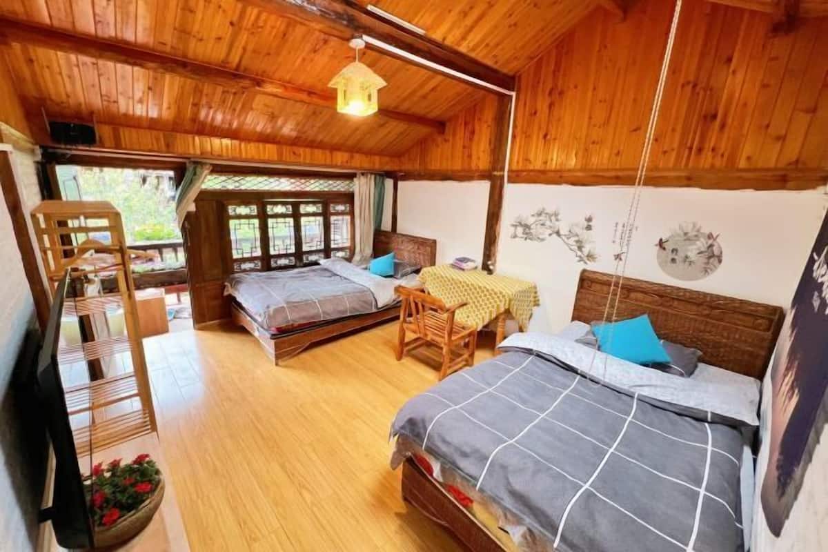 A wooden room with two beds, a wooden ladder, and a table with a yellow tablecloth.
