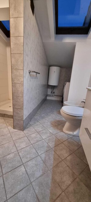 A modern bathroom with a toilet, a white sink, and a shower area. - Paradise Inn 2 (Livorno)