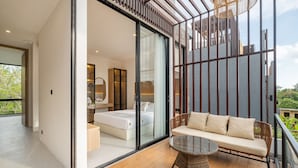 A modern bedroom with a large sliding glass door leading to a balcony.