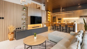 A modern kitchen with a large island, built-in appliances, and a dining area with bar stools.