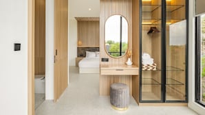 A modern bedroom with a large mirror, a bedside table, and a wardrobe.