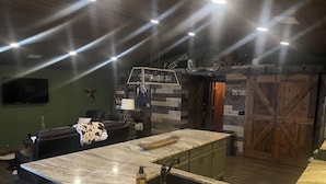 Una cocina moderna con una isla grande, taburetes de bar y una decoración rústica.