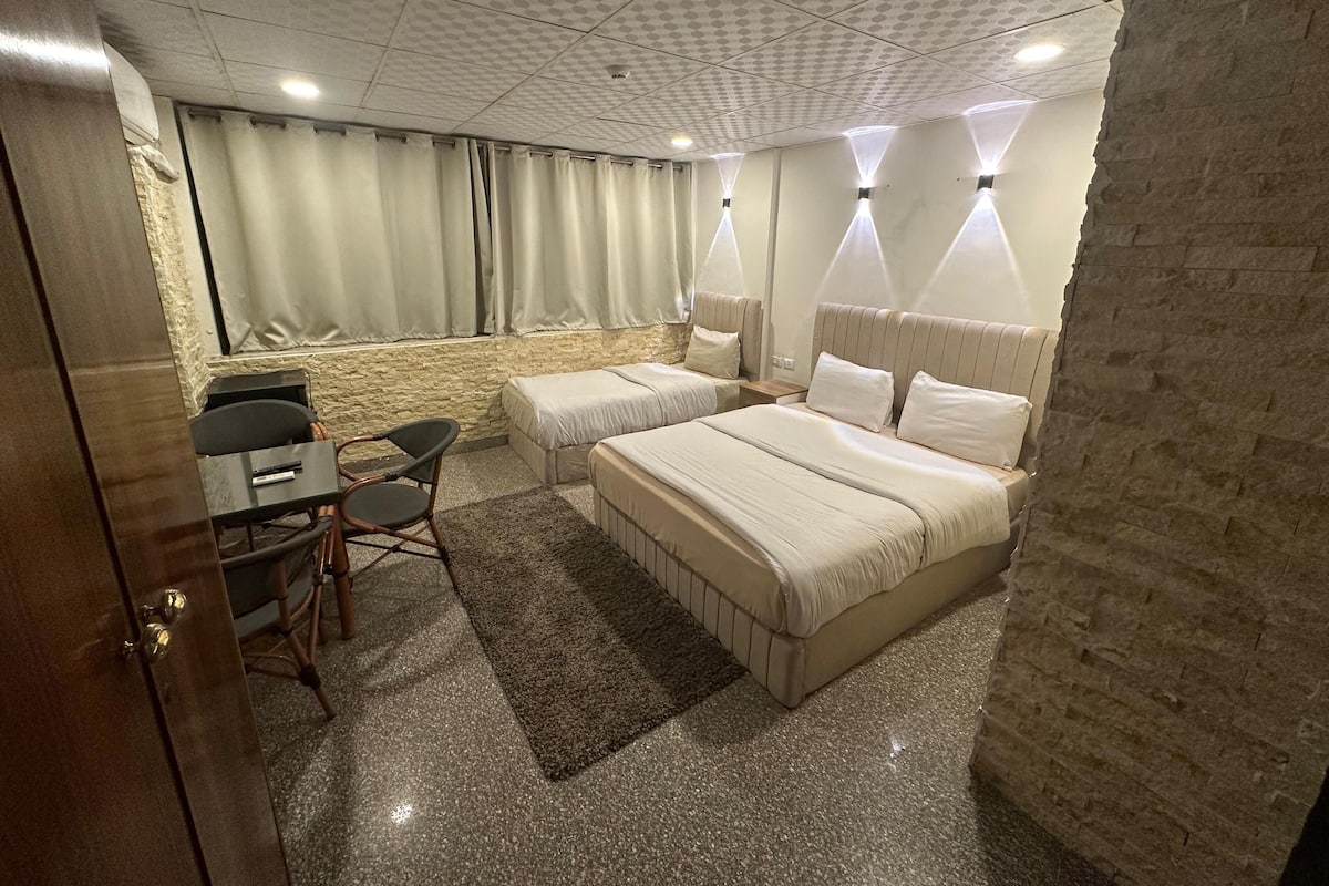 Una habitación de hotel con cama, escritorio y silla.