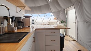 A compact kitchen with a wooden countertop, white cabinets, and a view through a large window. - Hot Tub Dome with Epic Ridge Views- Hickory Heights (Stanton)