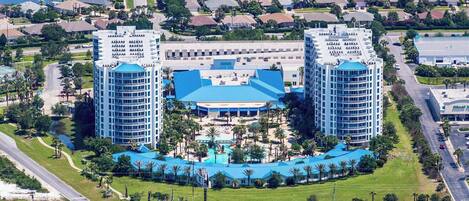 Un grand hôtel doté d’une piscine centrale et de deux tours symétriques.