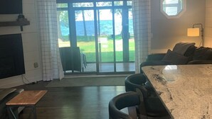 Una cocina moderna con barra, puertas correderas de vidrio que dan a un balcón con vistas al mar.