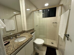 Een haardroger, handdoeken, zeep, toiletpapier