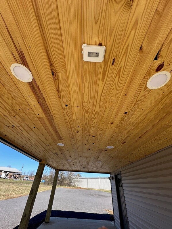 A ceiling with wooden panels and recessed lighting.