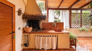 A kitchen with a large stove, a sink, and a window overlooking a garden. - Villa Mirto – Cozy Cottage with Garden and Terrace (Is Molas)