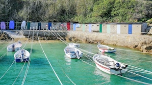A marina with several small boats tied to the dock, a stone wall, and colorful buildings in the background. - Lovely apartment in Saint-Christophe-du-Fo (Saint-Christophe-du-Fo)