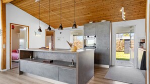 A modern kitchen with a central island, pendant lighting, and a view of the outdoors. - Gorgeous home in Hals with WiFi (Hals)