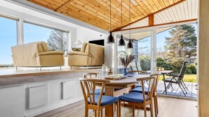 A modern kitchen with a dining area, large windows, and a view of the outdoors. - Gorgeous home in Hals with WiFi (Hals)