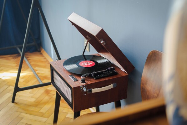 En træpladeafspiller med en vinylplade, placeret på en stol.