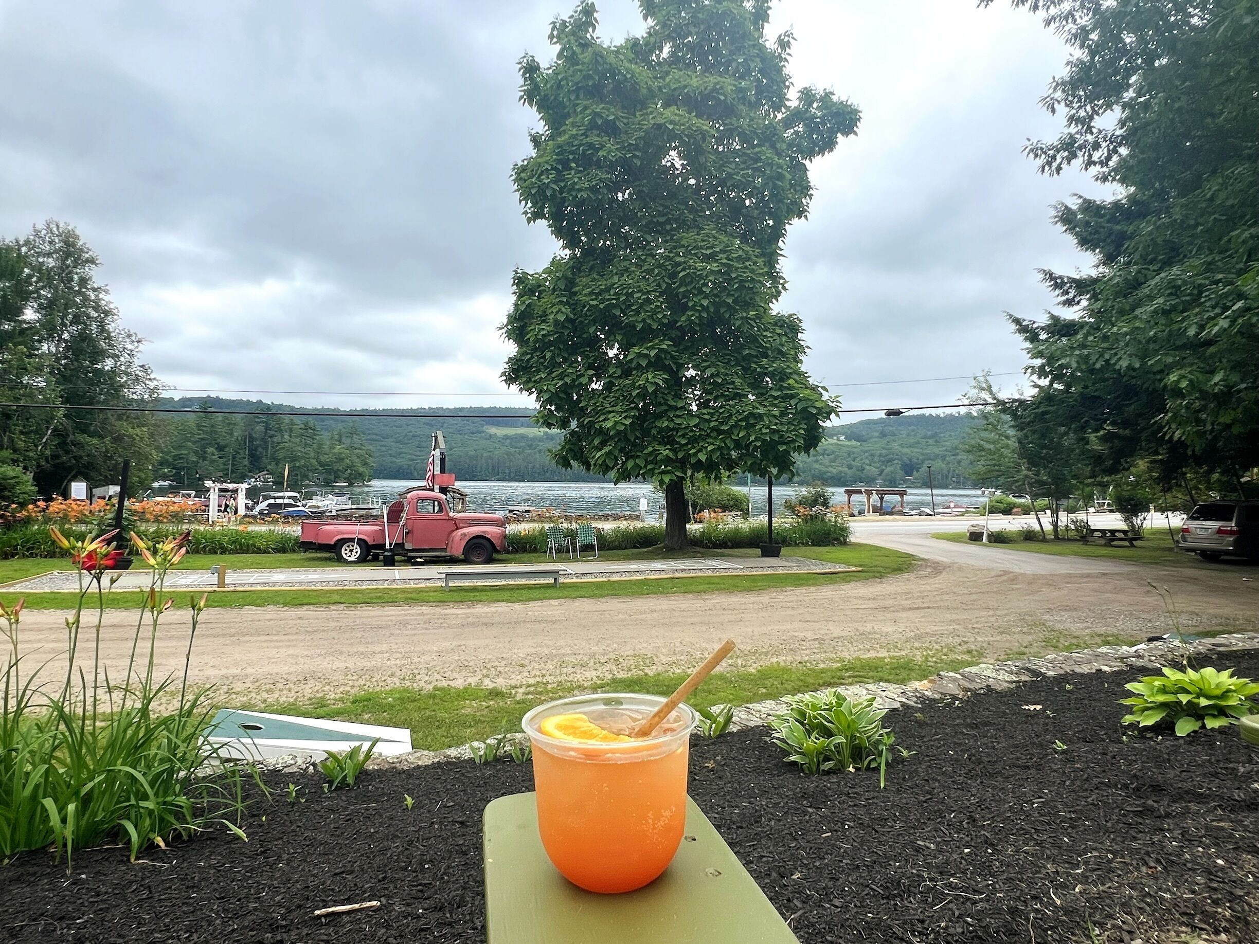 A scenic outdoor area with a table, a drink, and a red truck in the background.
