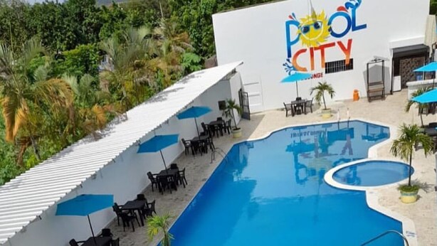 A pool area with multiple pools, sun loungers, and a building labeled "Pool City." - Hotel pool city  (Bonao)