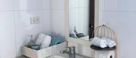 A bathroom with a white sink, a mirror, and a towel rack.