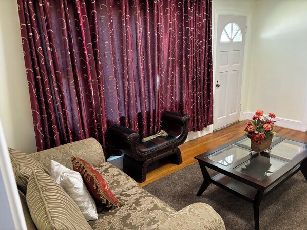 A living room with a sofa, armchair, and coffee table.