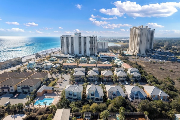 Ein Küstenresort mit mehreren Hochhäusern, einer Strandpromenade und einem Poolbereich.
