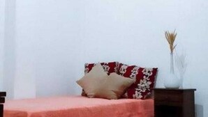 A bedroom with a bed, a nightstand, and a vase with dried plants. - Spacious 2-bedroom apartment in lovely Botafogo Rio de Janeiro with WiFi (Botafogo Rio de Janeiro)