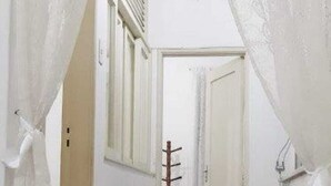 A narrow hallway with a coat rack and a door at the end. - Spacious 2-bedroom apartment in lovely Botafogo Rio de Janeiro with WiFi (Botafogo Rio de Janeiro)