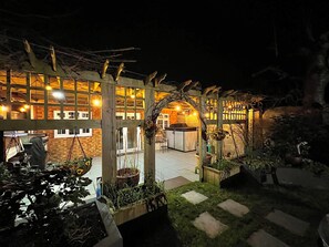 Un restaurante con terraza, fachada de ladrillo y luces colgantes.