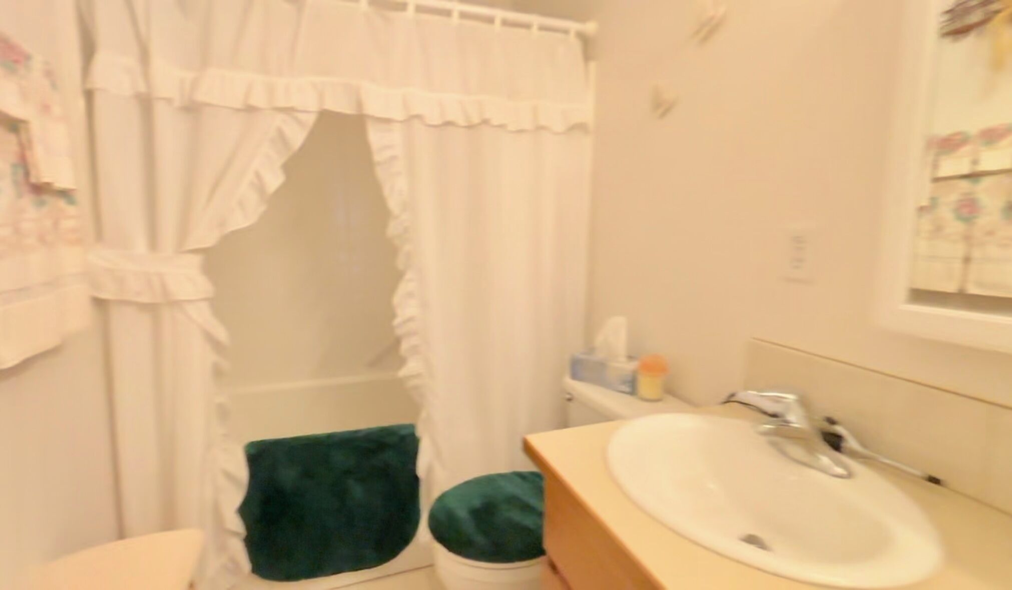 A bathroom with a white sink, a mirror, and a shower curtain.