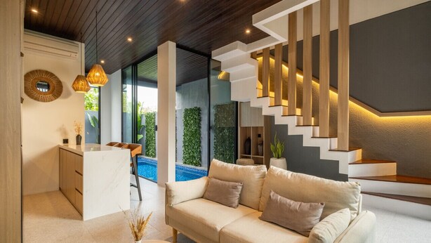 A modern living room with a sofa, a coffee table, and a staircase with built-in lighting. - Tropical Private Pool Villa 8C, 10min - Melasti Beach (Pecatu)