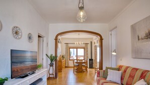 A living room with a TV, sofa, and dining area. - Nice house with 3 bedrooms, barbecue and private pool (Alcúdia)