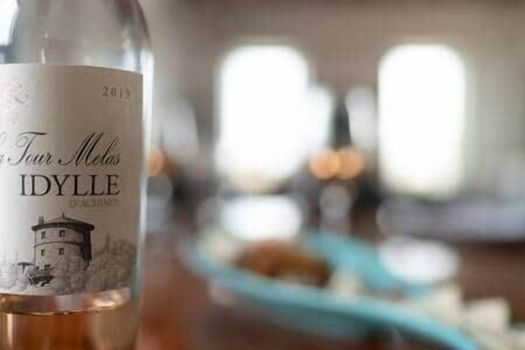 A bottle of Idylle wine with a label featuring a lighthouse and the text 'Tour Melon.'