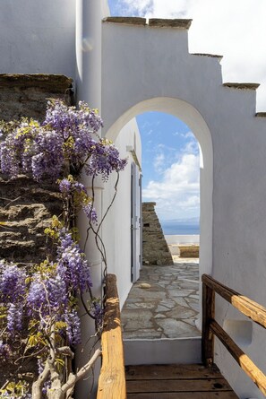 A stone pathway leading to a white building with an arched entrance. - Tinos Olive Mill House, Tinos Olive Mill House (Ktikados)