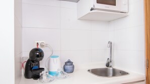 A compact kitchenette with a microwave, coffee maker, and a small refrigerator. - Playa Hotel - Cavancha (Iquique)