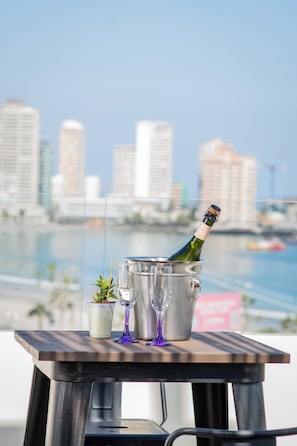 A table with a bottle of champagne, two glasses, and a small plant. - Playa Hotel - Cavancha (Iquique)